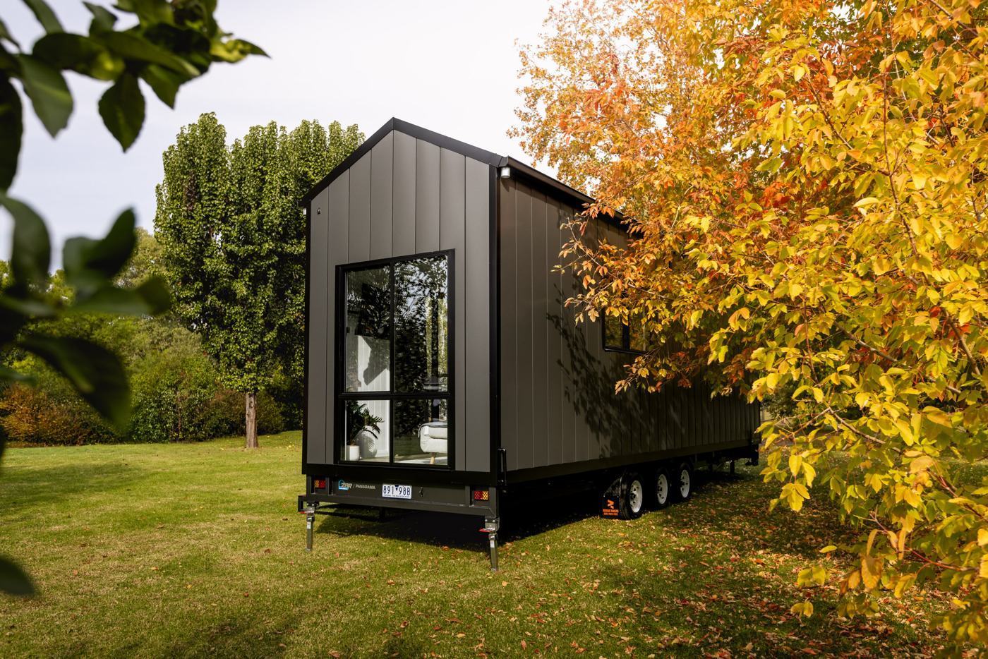 Gable end of the Panarama tiny home among autumn trees