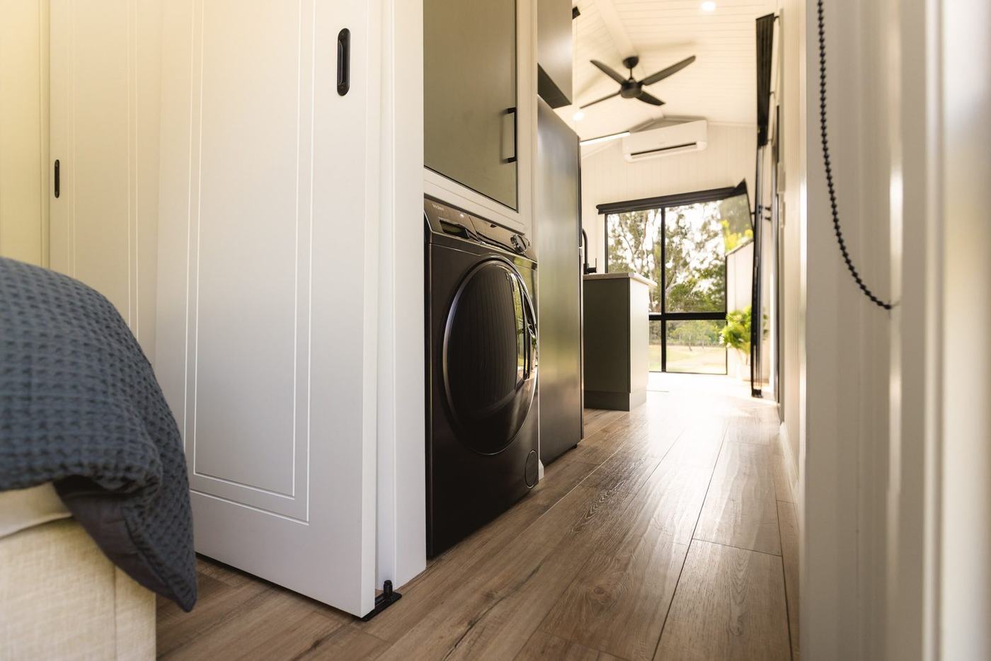 Hallway of the Panarama with laundry and barn door opening to the kitchen and living area