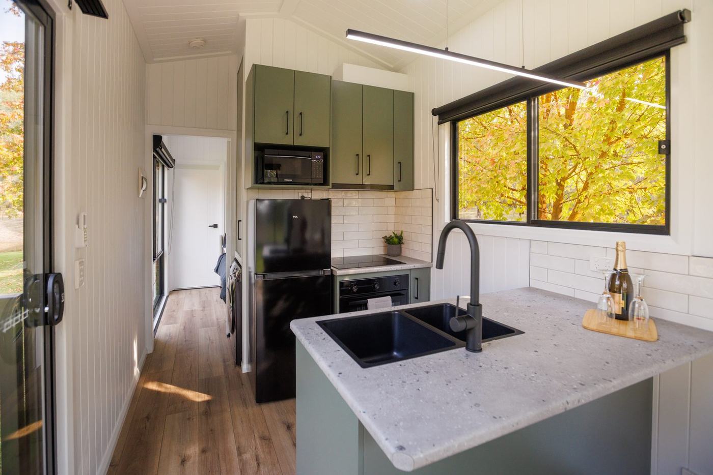 Kitchen island bench with sink and window overlooking autumn trees in the Panarama